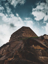 Low angle view of old building against cloudy sky