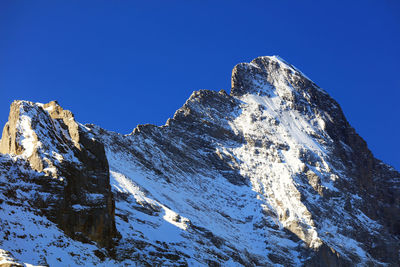 Low angle view of mountain against clear blue sky