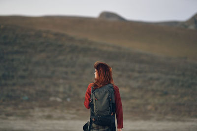 Rear view of woman standing against sky