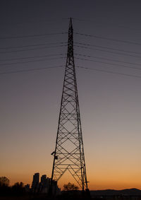 Silhouette electricity pylon against sky during sunset