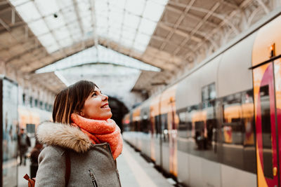 Woman standing by train at railroad station