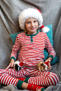 Portrait of cute girl sitting on sofa at home