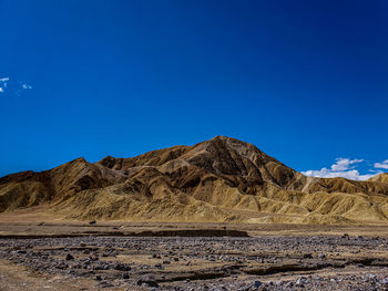 Scenic view of desert against blue sky