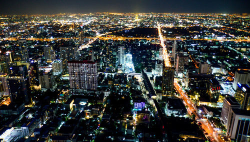 High angle view of city lit up at night