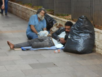 Young couple sitting on footpath