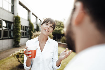 Portrait of a smiling young woman drinking water