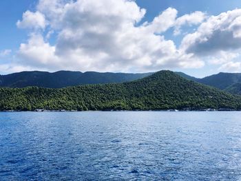 Scenic view of lake by mountains against sky