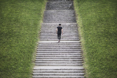 High angle view of young man climbing staircase