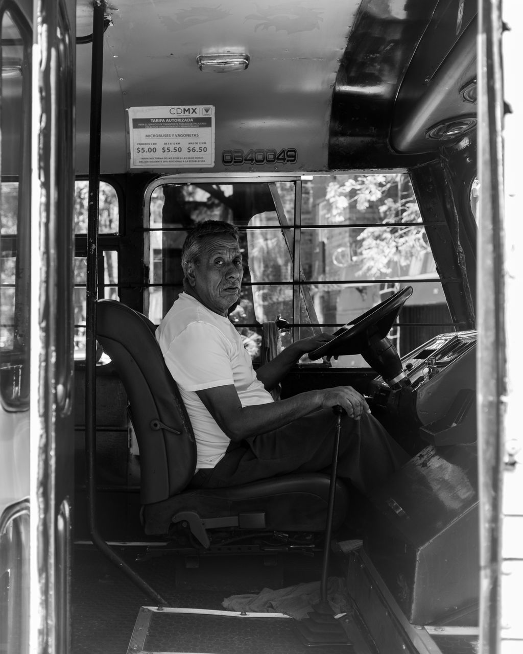 sitting, one person, real people, mode of transportation, men, vehicle interior, transportation, vehicle seat, seat, adult, communication, land vehicle, technology, full length, side view, males, wireless technology, public transportation, driving, mature men