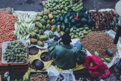 Rear view of man selling fruits and vegetables at market