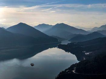 Scenic view of lake and mountains against sky