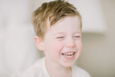 Closup of toddler boy laughing with eyes closed