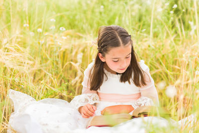 Portrait of young woman sitting on field