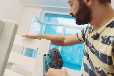 Side view of man feeding bird