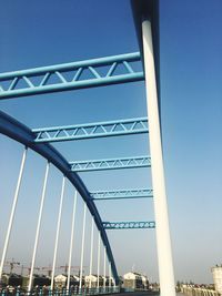 Low angle view of suspension bridge against blue sky