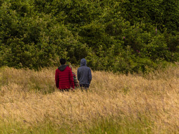 Rear view of people walking on grass