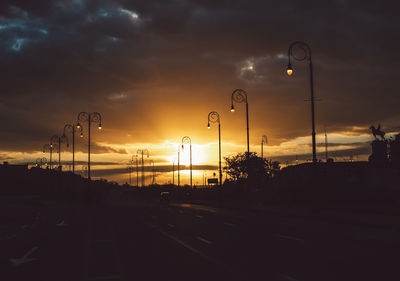 Silhouette street against sky during sunset