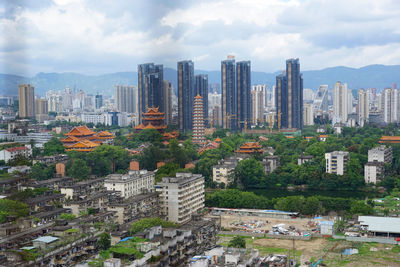 Buildings in city against cloudy sky