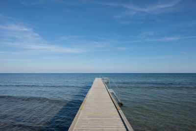 Pier over sea against blue sky