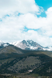 Scenic view of snowcapped mountains against cloudy sky