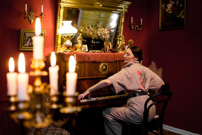 Rear view of woman sitting on table