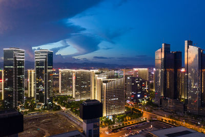 Illuminated buildings in city against sky at night