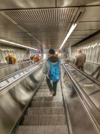 Woman standing on escalator