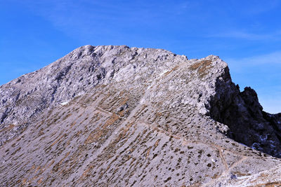 Low angle view of mountain against blue sky