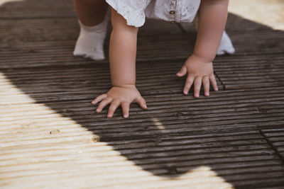Low section of baby on wooden floor