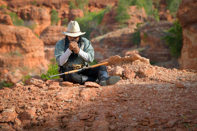 A cowboy man sitting and resting to smoke to relax