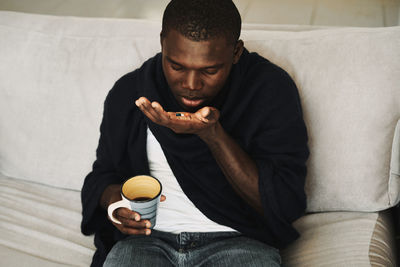 Full length of man sitting on sofa