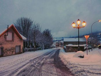 Empty road passing through snow covered landscape