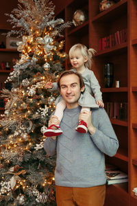 Full length of a smiling girl with christmas tree