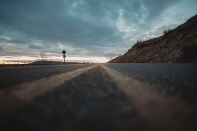 Surface level of road against sky during sunset