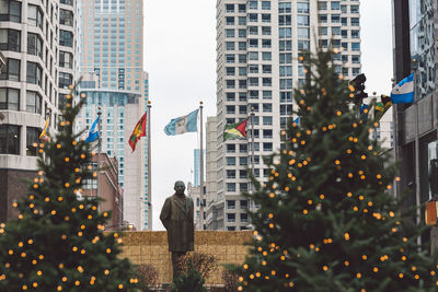 Statue amidst buildings against sky in city