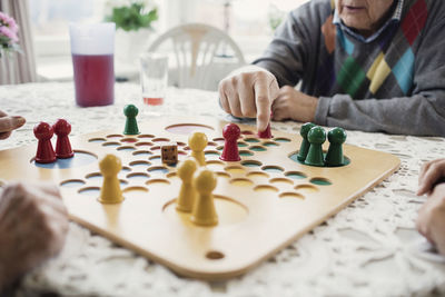 Cropped image of people playing ludo in nursing home