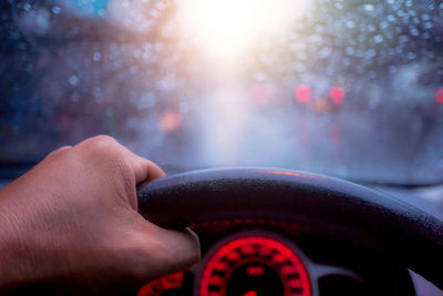 Cropped image of person hand holding glass of car