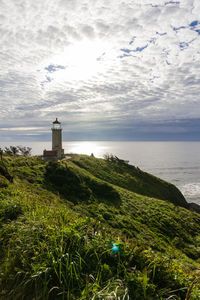 Lighthouse by sea against sky