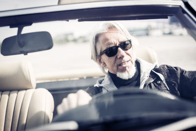 Portrait of woman wearing sunglasses in car