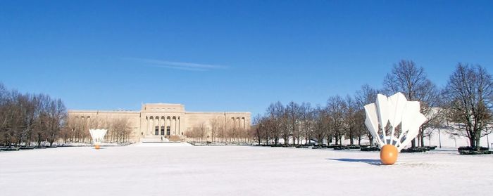 Snow covered built structure against blue sky