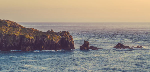 Scenic view of rocks amidst sea against sky