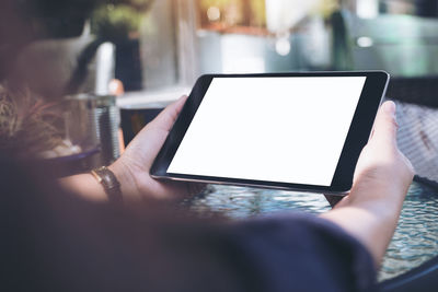 Midsection of woman holding digital tablet