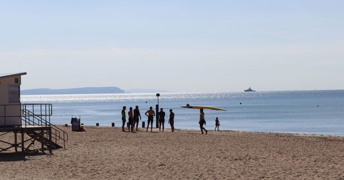 People on beach against sky