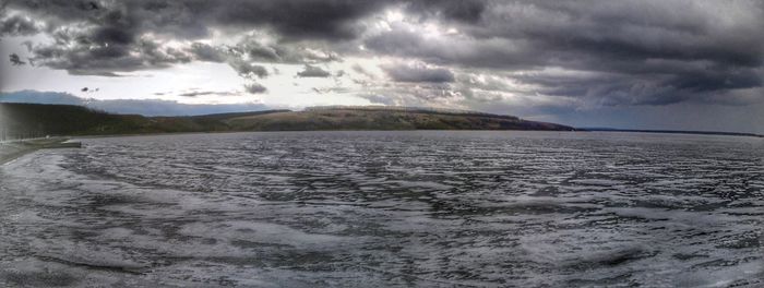 Scenic view of lake against cloudy sky