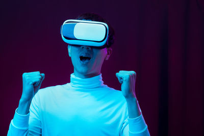 Man looking at camera while standing against blue background