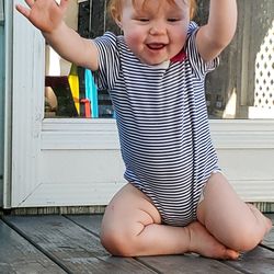 Baby girl playing while sitting on wood