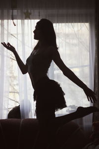 Woman dancing by window at home