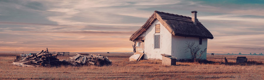 Abandoned house on field against sky