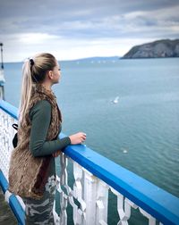 Woman looking at sea against sky