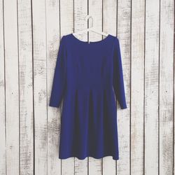 Dress hanging against wooden wall